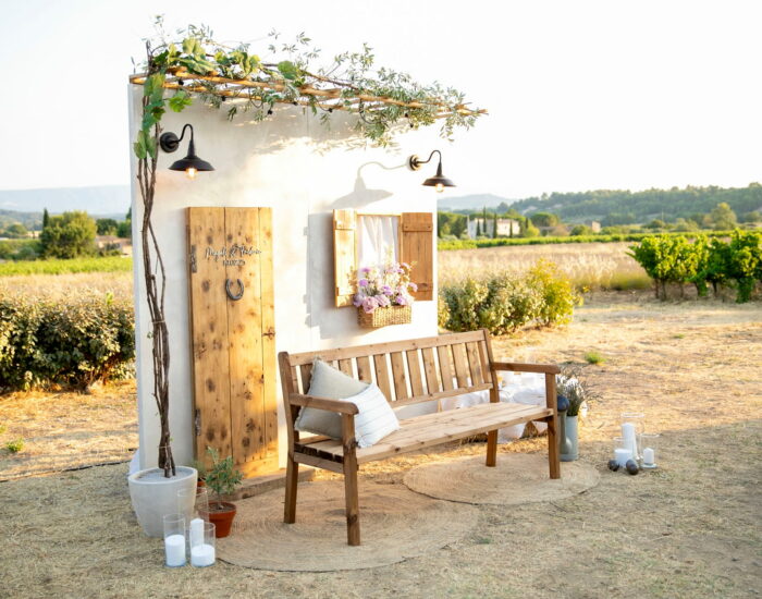 Décor photocall d'une maison champêtre avec un banc, en pleine nature